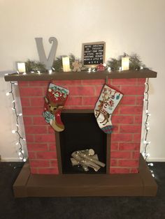 a fireplace decorated with stockings and lights