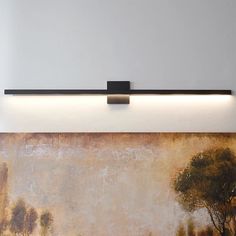 a painting is hanging on the wall next to a light that has been turned on