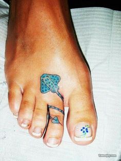 a person with a blue flower tattoo on their foot and one has a small fish on it's toe