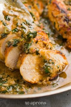 a close up of a plate of food with chicken and spinach sauce on it