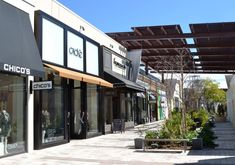 an empty sidewalk in front of some shops