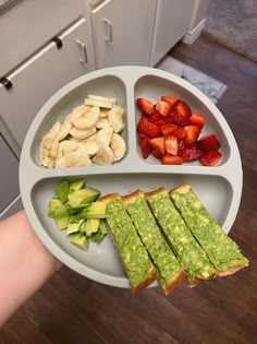 a person holding a plate with some food on it and strawberries in the background