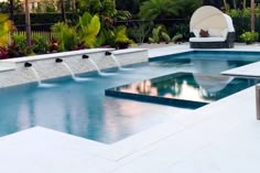 an outdoor swimming pool surrounded by trees and plants