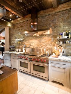 a kitchen with an oven, stove and counter tops in stone walled wallpapered walls