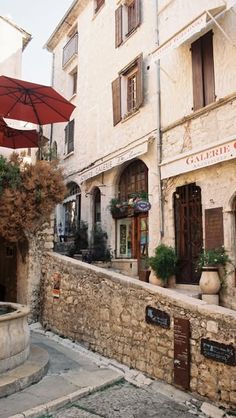 an umbrella is hanging on the side of a building with stone walls and steps leading up to it