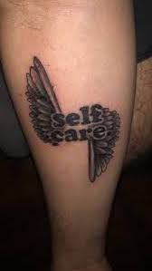 a tattoo on the leg of a person with an angel wing and scissors in it