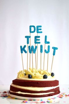 a cake with candles that say de tel kwltt on it and the words de tel kwltt spelled in blue frosting