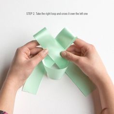 someone is making a bow out of green paper