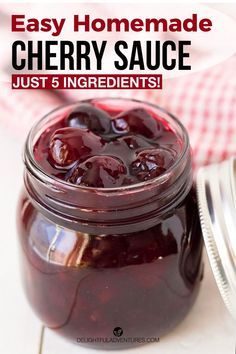 a jar filled with cherry sauce sitting on top of a table