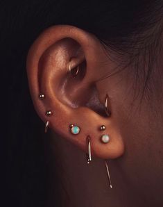 a close up of a person with ear piercings on their ears and behind the ear