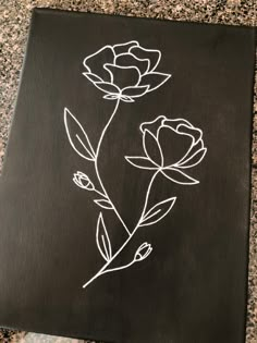 a black board with white flowers painted on it