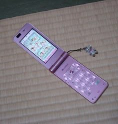 a pink cell phone sitting on top of a mat