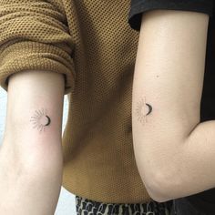 two people with matching tattoos on their arms, one has a sun and the other has a moon