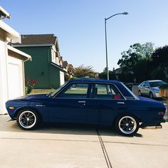 a blue car parked in front of a house