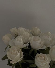 a vase filled with white roses on top of a table