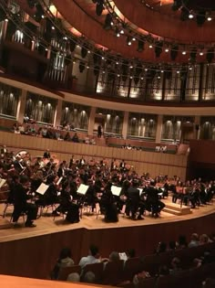 an orchestra performing on stage with lots of people