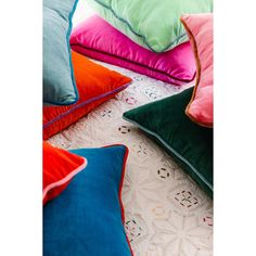 several different colored pillows laying on top of a white doily next to each other