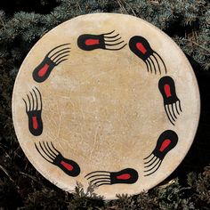 an image of a plate that is on the ground with some red and black designs