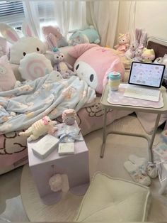 a room filled with lots of stuffed animals next to a laptop on top of a table