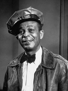 a black and white photo of a man with a hat on top of his head