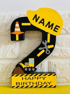 the number 2 is made out of construction equipment and has a name on it that says happy birthday