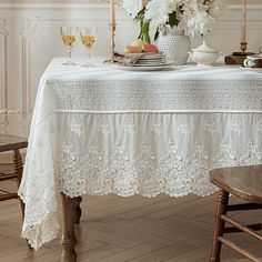 a table with white flowers and plates on it