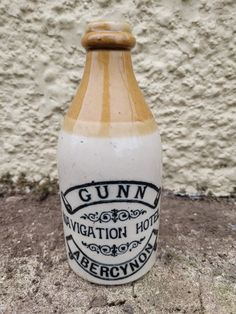 a bottle that is sitting on the ground next to a wall and some concrete walls