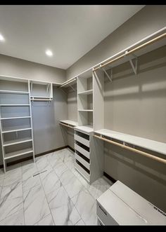 an empty walk in closet with shelves and drawers