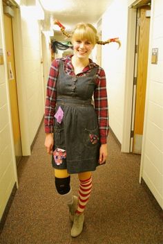 a woman in an apron and tights is standing in a hallway with her hair blowing up