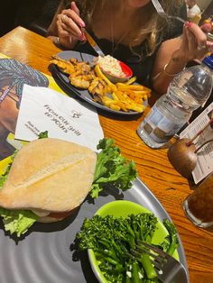 a woman sitting at a table with plates of food