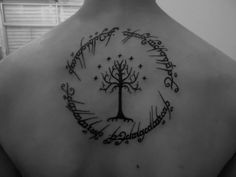 the back of a man's shoulder with a tree and stars tattoo on it