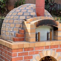 an outdoor brick pizza oven with the door open