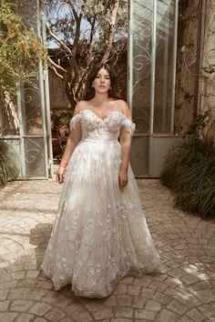 a woman in a wedding dress standing outside