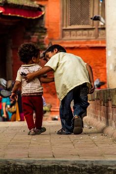 two young boys playing with each other on the street