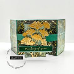 an open card box with flowers on it and the words thinking of you written in green