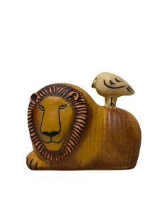 a wooden statue of a lion and a bird