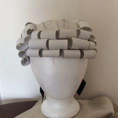 a white mannequin head with grey and black hair clips on it