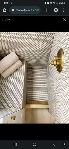 a bathroom with white and gold wallpaper, toilet paper roll and towel rack in the corner