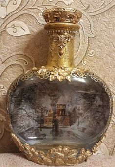 an ornate glass bottle with a painting on it