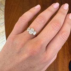 a woman's hand with a three stone ring on top of her left hand