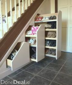 an under stairs storage unit with shoes underneath