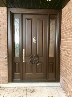 the front door is brown and has two sidelights on each side, with an ornate design