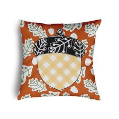 an orange pillow with leaves and acorns on it