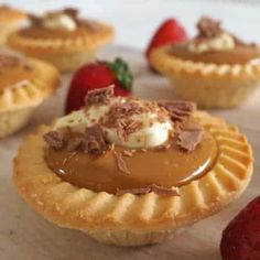 some desserts are sitting on a table with strawberries