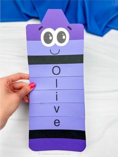 a person holding up a purple piece of paper with the word ovie on it