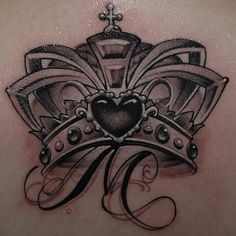 the back of a woman's chest with a crown and heart tattoo on it