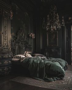 an ornate bedroom with green bedding and chandelier hanging from the ceiling, along with antique furniture