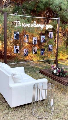 a white couch sitting on top of a grass covered field next to a wooden table