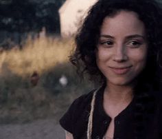 a woman with curly hair standing in the street