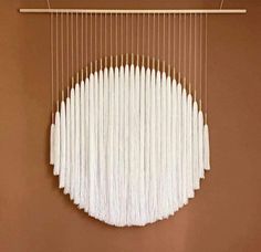 a large white object hanging from a wooden frame on a wall with strings attached to it